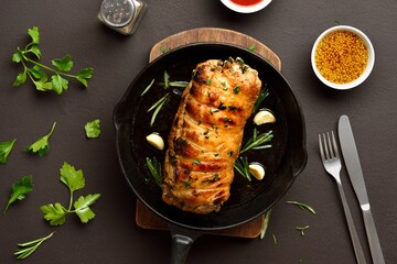 Oven baked pork loin with rosemary and garlic in cast iron pan