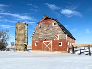 Almost painting like - red barn, old silo, blue sky, whispy clouds, and pure white snow