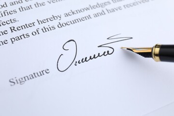 Fountain pen leaving signature on contract, closeup