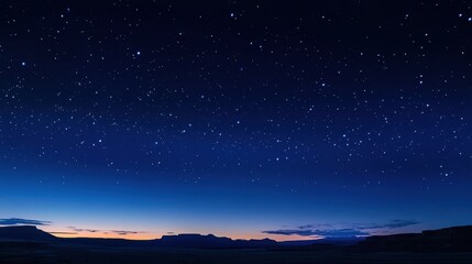 Fototapeta premium A serene night sky filled with shimmering stars and a gradient of deep blue to soft orange, creating a tranquil ambiance in the wilderness.