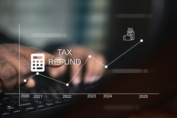 A business person's hand types on a keyboard with a digital graph showing tax refund trends from...