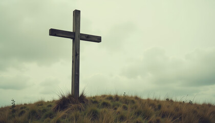 Old wooden cross on hilltop under cloudy sky, vintage solitude