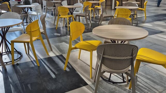 Empty tables and chairs of a cafe during the day without customers