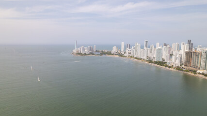 Obraz premium Cartagena skyline dominating the caribbean coastline with sailboats navigating the bay