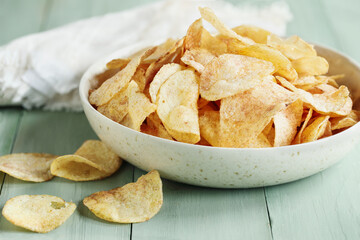 Crispy potato chips in a bowl over a bright table