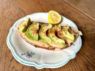 Avocado and peanut butter toast in plate on wooden table