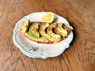 Avocado and peanut butter toast in plate on wooden table