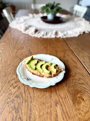 Avocado and peanut butter toast in plate on wooden table