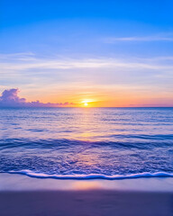 Fototapeta premium Sunrise over a sandy beach with gentle waves breaking, scenic backdrop for tourism