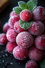 Fresh red frosted grapes with mint leaves on a dark background close-up