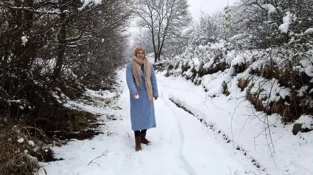 Young woman is walking in a forest near the ruins of the Castle of Hasznos near Paszto
