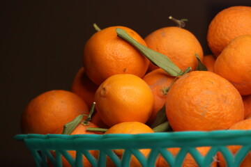Fresh small oranges in plastic basket