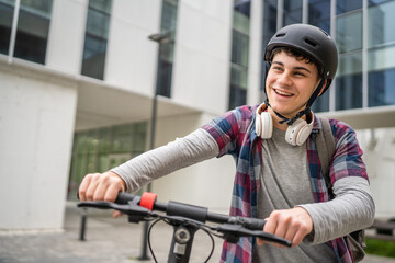 Naklejka premium Young man caucasian teenager with electric kick push scooter in city
