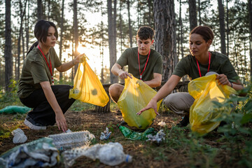 teenage friends young men women pick up waste garbage to clean forest