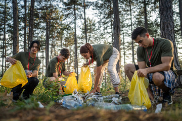 teenage friends young men women pick up waste garbage to clean forest