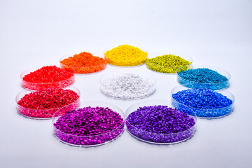Various colors of masterbatch granules in petri dish isolated on white background,color pigment carrier polymer in plastic industry.Perfect for plastic company catalog design