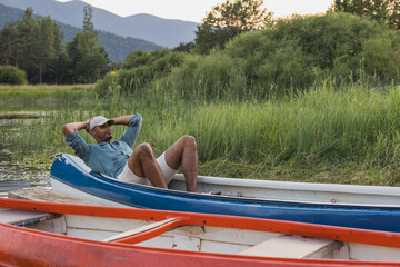African American man relaxing in a canoe on a lake in nature
