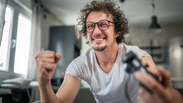 man play console video games at home hold joystick controller have fun