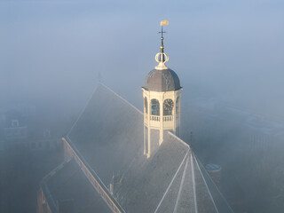 aerial drone photo church spire roof in fog morning Sneek