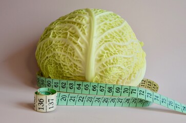 A head of fresh cabbage and a centimeter at the waist. Weight loss concept