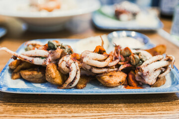 restaurant dish, fried squid with potatoes on a platter