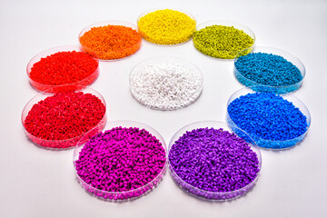 Various colors of masterbatch granules in petri dish isolated on white background,color pigment carrier polymer in plastic industry.Perfect for plastic company catalog design