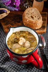 Sour rye soup with pieces of white sausage and mushrooms.
