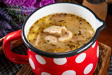 Sour rye soup with pieces of white sausage and mushrooms.