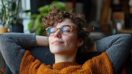 Young woman with glasses reclining on sofa with smile
