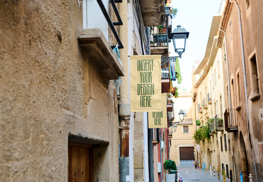 Hanging banners adorn the facades of small businesses in a city street, highlighting local ads