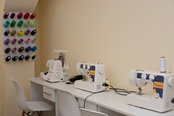 Sewing machine with fabric on table in tailor workshop