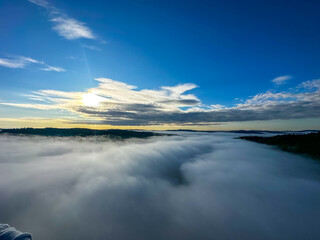 A beautiful sunrise in the sky over the morning fog. View from a hot air balloon. Europe