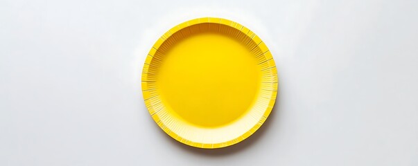 Yellow paper plate displayed on a pristine white surface, top view capture.
