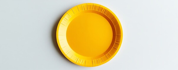 Yellow paper plate displayed on a pristine white surface, top view capture.