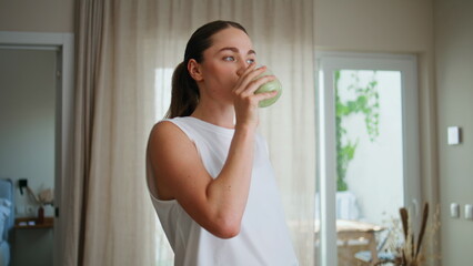 Morning girl drinking smoothie at light apartment room closeup. Smiling woman