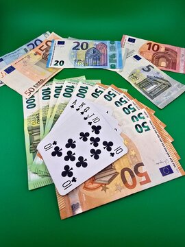Playing cards and money on a green background.