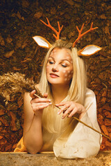 Face art. Drawing on the face. Woman painted as a deer. Drawing of an animal on the face. Fairytale image of a woman natural isolated.