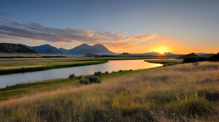 Serene Sunset Over Grassland River and Distant Mountains