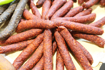 Close up composition of traditional hungarian homemade specialty foods, salami sausage etc. on farmers market for sale. Pile of delicious regional homemade products in row