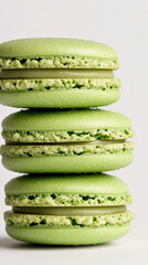 Elegant green matcha macarons stacked beautifully on a white background