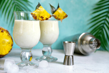 Traditional caribbean cocktail pina colada with ingredients for making : cream, pineapple, coconut...