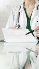 Female doctor in a hospital setting is pointing at medical chart, showcasing expertise in a close up shot. Medicine