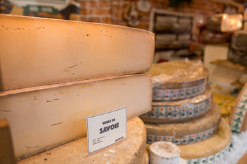 Delicious cheese varieties displayed at a market in Savoie, France during summer