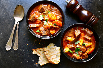 Goulash (meat stew with tomatoes and paprika) - traditional dish of hungarian cuisine.Top view with copy space.