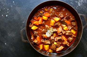 Goulash (meat stew with tomatoes and paprika) - traditional dish of hungarian cuisine.Top view with copy space.