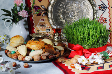 Traditional Azerbaijan holiday Novruz background with green semeni,traditional azerbaijan sweets,shekerbura,qogal,paxlava,mutaki and different nuts and sweets,top view,space for copy