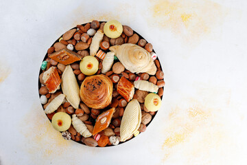 Traditional Azerbaijan holiday Novruz background with green semeni,traditional azerbaijan sweets,shekerbura,qogal,paxlava,mutaki and different nuts and sweets,top view,space for copy
