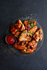 Grilled spicy chicken wings with ketchup  . Top view with copy space.