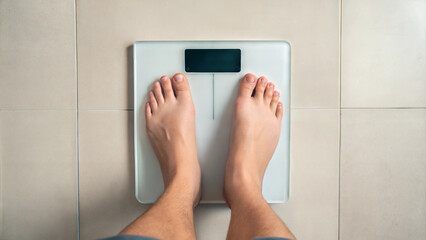 Person weighing self on digital scale bathroom lifestyle image top view health concept