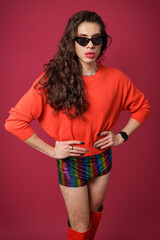 non-binary person is posing on a red studio background Man has an artistic expression. Concept of non-binary people. pride